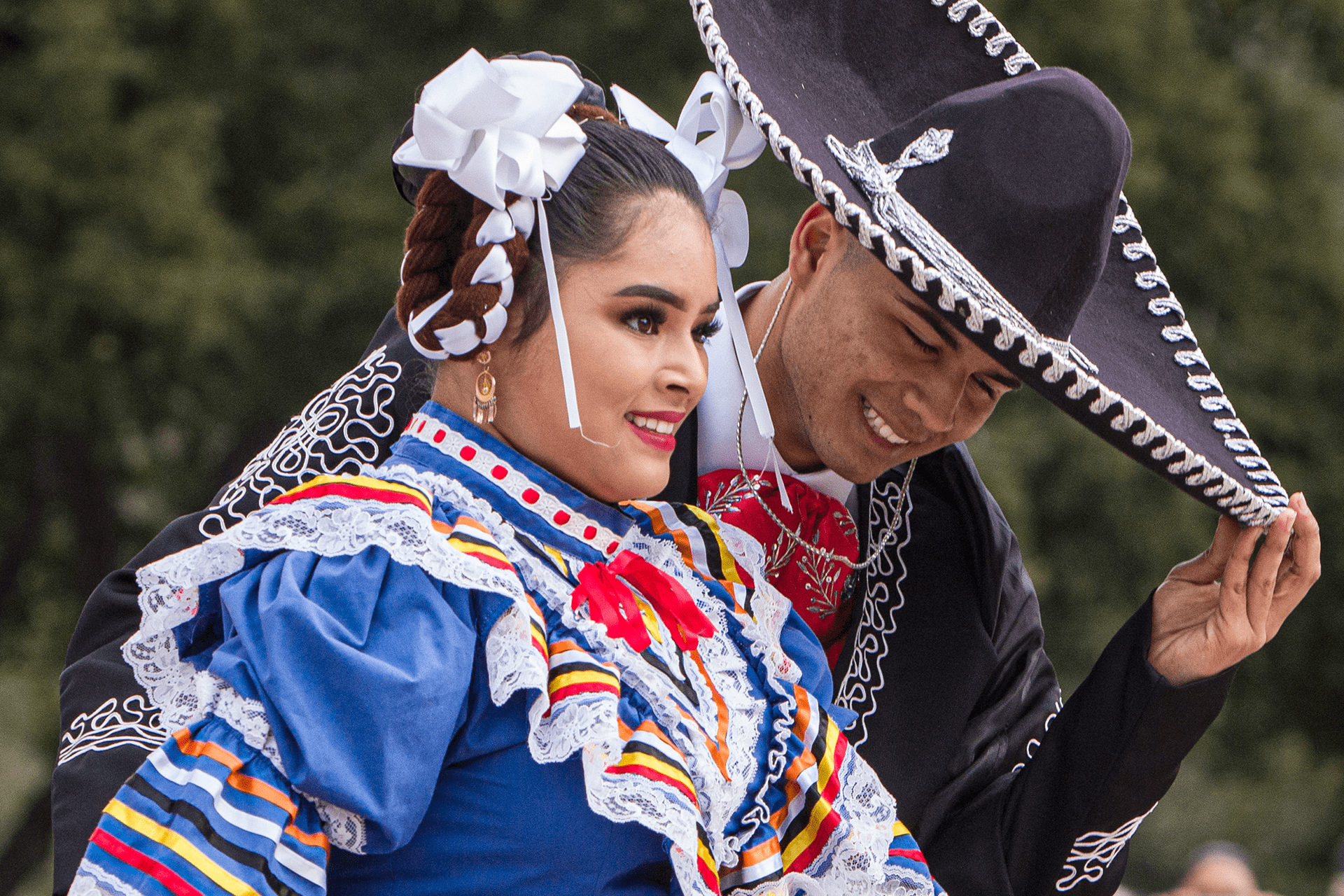 Close-up image of two Folkloric Dancers in traditional costume; the gentleman tipping his sombrero to the lady - Photo by Keith Bergher